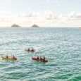 Kayakers paddling in kailua bay with the Mokulua Islands and Lanikai Beach in the distance